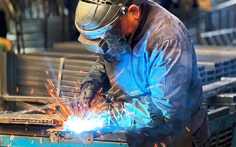A worker is welding a shelf